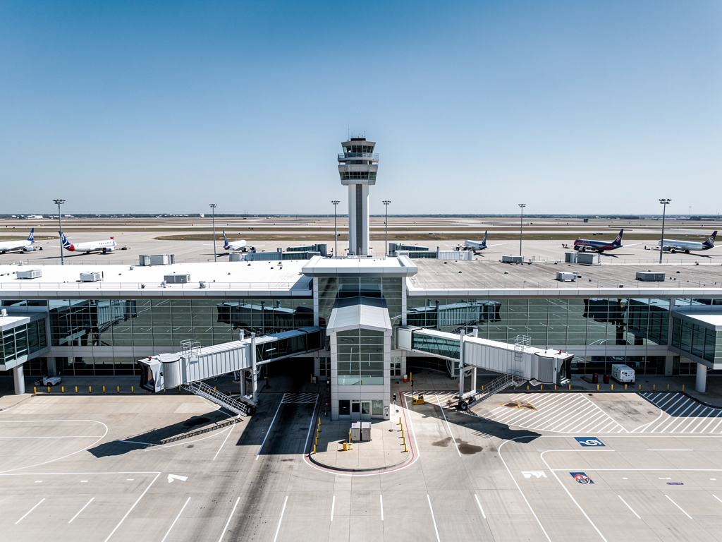 Dallas Fort Worth International Airport terminal exterior with large modern terminal layout and runways,
